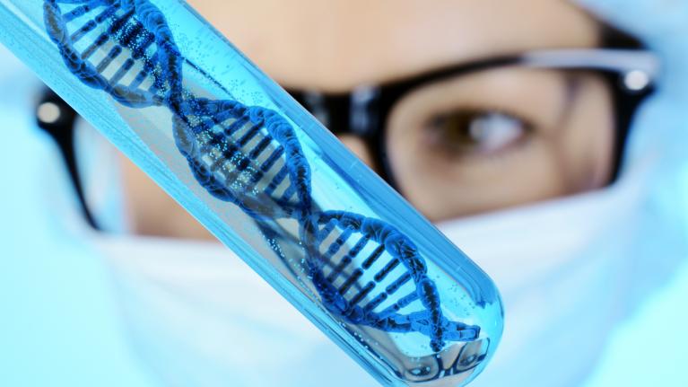 Forscherin hält Genom im Reagenzglas in der Hand
